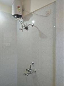 een badkamer met een douchekop aan de muur bij Sai Leela Guest House in Dabolim