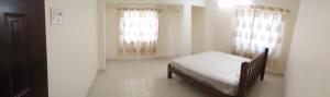 a bedroom with a bed and two windows at Sai Leela Guest House in Dabolim