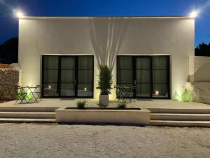 a white building with two windows and a potted plant at Villa Anna Maria Otranto in Otranto