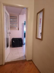 a hallway with a door open to a room with a suitcase at Apartmani Neven in Irig
