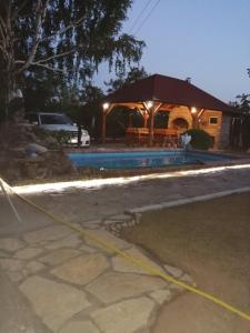 a house with a swimming pool and a pavilion at Apartmani Neven in Irig