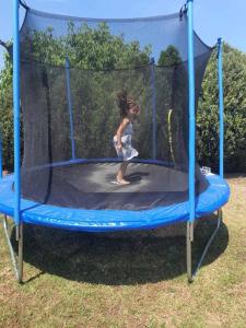 a little girl playing on a trampoline at Apartmani Neven in Irig