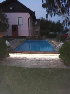 a swimming pool in front of a house at Apartmani Neven in Irig