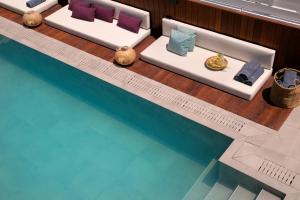 a pool with two beds next to a swimming pool at Chris Le Mare Gold Luxury Villa in Protaras