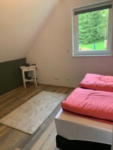 ein Schlafzimmer mit einem roten Bett und einem Fenster in der Unterkunft Ferienhaus Pfefferminzhütte in Mildenau