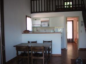 a kitchen with a table and chairs in a room at Locations A Suara in Porto-Vecchio