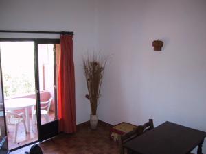 Sala de estar con mesa y jarrón con ramas en Locations A Suara, en Porto Vecchio