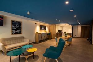 a living room with a couch and chairs and tables at Alameda Rooms Santiago in Santiago de Compostela