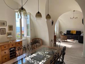 - un salon avec une table et des chaises en verre dans l'établissement Grand Appartement Centre historique Grasse, à Grasse