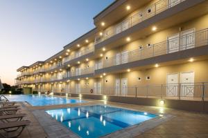 um hotel com piscina em frente a um edifício em Chrissy's Paradise em Agia Pelagia