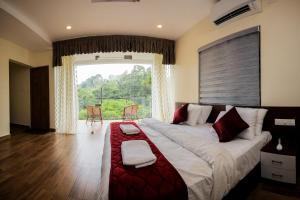 a large bed in a room with a large window at Thenmala Hormuz Inn in Kolattupuzha