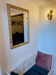 a mirror on a wall with a couch in a room at Apartment Styria Lent in Maribor