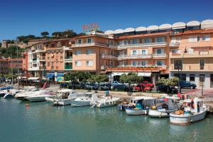 a group of boats docked in a marina next to a building at Hotel L'Approdo in Castiglione della Pescaia