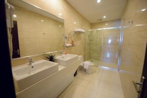 um banheiro com pia, chuveiro e vaso sanitário em Timor Plaza Hotel & Apartments em Dili