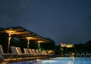a group of chairs sitting next to a pool at night at Villa Del Mar in Vasiliki