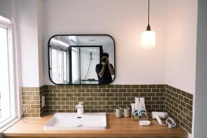 eine Person, die ein Bild von einem Badezimmerspiegel macht in der Unterkunft 薄荷巴黎 Coffee House in Taitung
