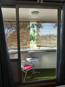 Cette chambre dispose d'une fenêtre avec une table et une chaise. dans l'établissement Pied à terre du front de mer, à Papeete