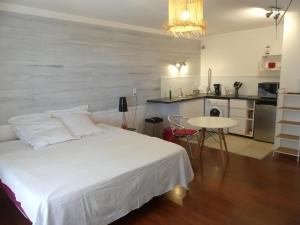 Cet appartement comprend une chambre avec un lit et une table ainsi qu'une cuisine. dans l'établissement Pied à terre du front de mer, à Papeete