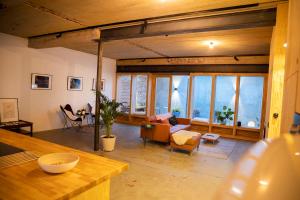 a living room with a couch and chairs and windows at Studio73, Guesthouse met sauna in Kortrijk