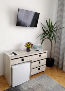 a white dresser with a tv on a wall at Check-In Kaya in Sibiu