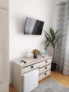 a white dresser with a tv on a wall at Check-In Kaya in Sibiu
