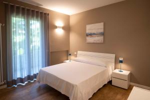 A bed or beds in a room at Sirmio Apartments - Narnia Stay