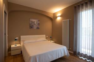 A bed or beds in a room at Sirmio Apartments - Narnia Stay