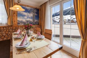 a dining room with a table with wine glasses at Hotel Garni Ida in Ischgl