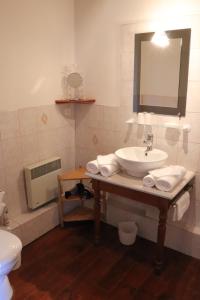 La salle de bains est pourvue d'un lavabo, de toilettes et d'un miroir. dans l'établissement L'Intemporelle, à Ozourt