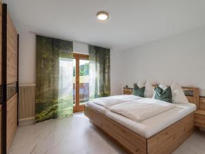 1 dormitorio con cama y ventana grande en Ferienhaus am Erlachhof, en Söll