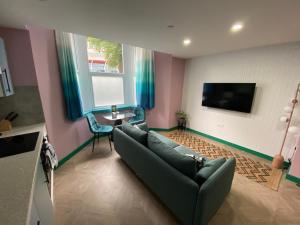 a living room with a couch and a tv at Aaron Wise - 51 Fitzhamon Apartments in Cardiff