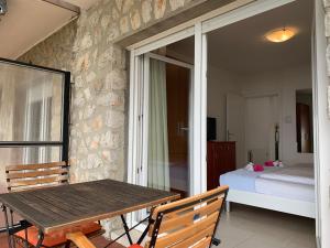 Habitación con mesa de madera y dormitorio. en Breathtaking sea view app for 2+1, BBQ ......, en Opatija