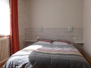 1 cama con cabecero de madera en un dormitorio en Les Cyclamens en Saint-Jean-de-Maurienne