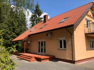 a house with a red roof and a porch at Willa Poziomka, Mielno, Grunwald in Mielno