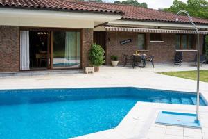 a swimming pool in front of a house at Casa Rural Oroimena in Andoain