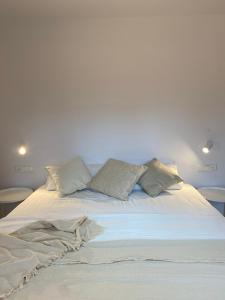 - un lit blanc avec des oreillers au-dessus dans l'établissement Apartamento M Garaje Playa Golf, à Zarautz