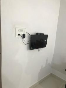 a tv on a wall in a white wall at Prestige Guest House in Bilāspur