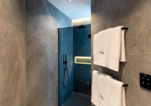 a bathroom with a shower with towels on a wall at Mauro Suites in León