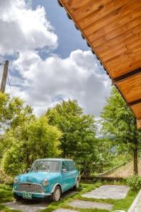 an old blue car parked under a wooden roof at 靜夜星空-8人包棟 in Wande