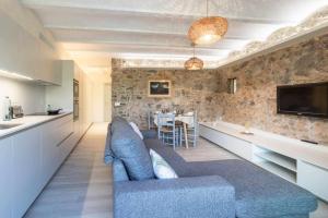 Sobrestany的住宿－OCELLS DE MONTGRÍ apartamento rural en el Baix Empordà，一间带蓝色沙发的客厅和一间厨房