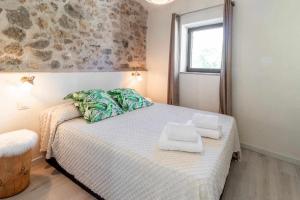 1 dormitorio con 1 cama con toallas en OCELLS DE MONTGRÍ apartamento rural en el Baix Empordà, en Sobrestany