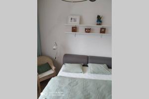 a bedroom with a bed and a white wall at A Cozy Studio in the City Centre in Bratislava