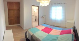 - une chambre avec un lit et une couverture colorée dans l'établissement Maison calme avec grand jardin en Sologne, à Chaumont-sur-Tharonne