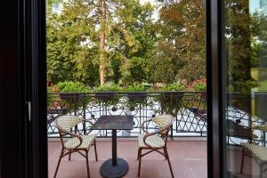 einen Tisch und Stühle auf einem Balkon mit Aussicht in der Unterkunft A Hoteli - Hotel Park in Vrnjačka Banja