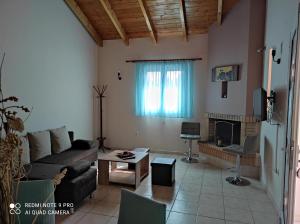 a living room with a couch and a fireplace at AK VILLAGE ROOMS in Dhrepanon