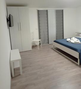 sypialnia z łóżkiem, krzesłem i lustrem w obiekcie Bouganville da Giò w mieście Scalea