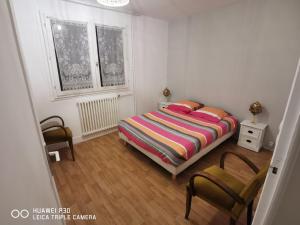 een slaapkamer met een bed en 2 stoelen. bij T2 cosy proche des pistes in Briançon