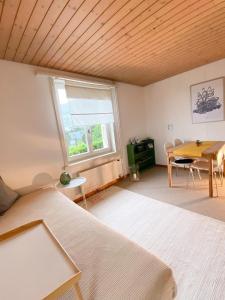 een kamer met een bed, een tafel en een raam bij NEB-THUN LODGE`s Appartement 1 Hilterfingen Ringstrasse 6 in Thun
