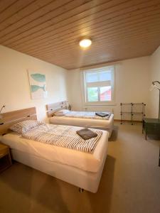 three beds in a room with a wooden ceiling at NEB-THUN LODGE`s Appartement 1 Hilterfingen Ringstrasse 6 in Thun