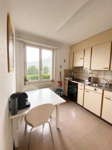 cocina con mesa blanca y ventana en NEB-THUN LODGE`s Appartement 1 Hilterfingen Ringstrasse 6 en Thun